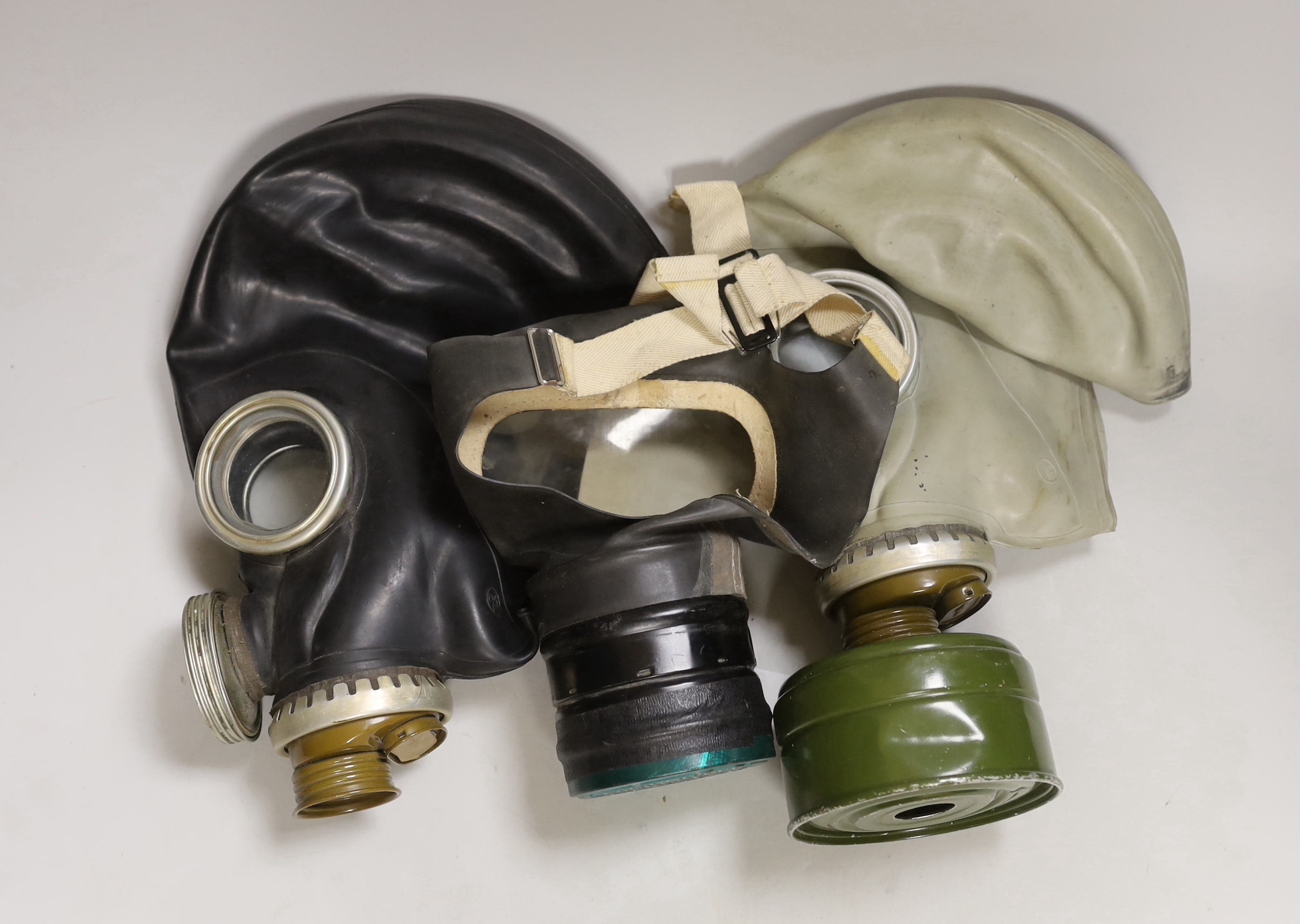 Three gas masks, including a boxed child’s mask with instructions on inside of the lid